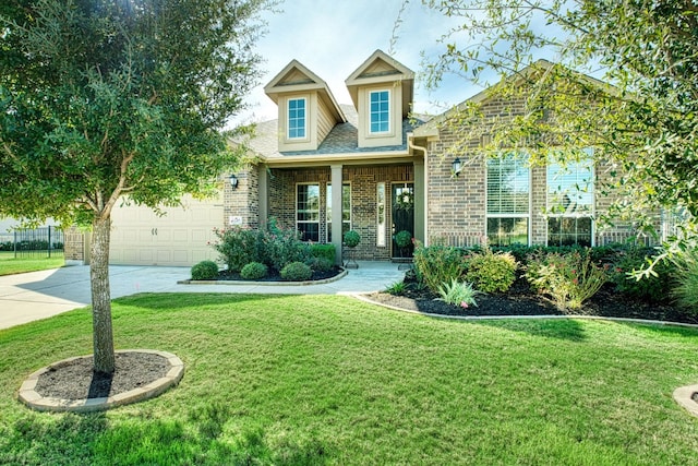 cape cod house featuring a front yard and a garage