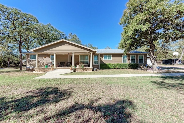 back of property with a yard and covered porch