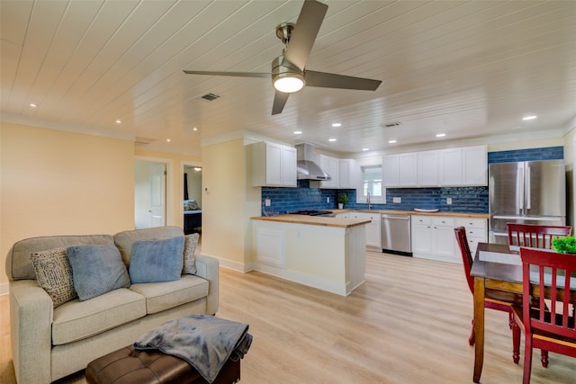 interior space featuring ceiling fan, sink, crown molding, and light wood-type flooring