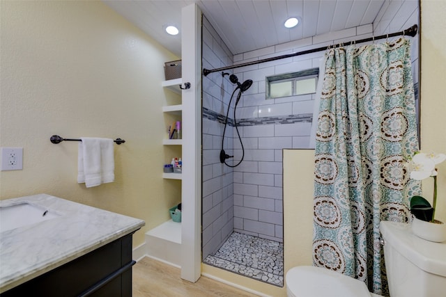 bathroom featuring wood-type flooring, vanity, toilet, and walk in shower