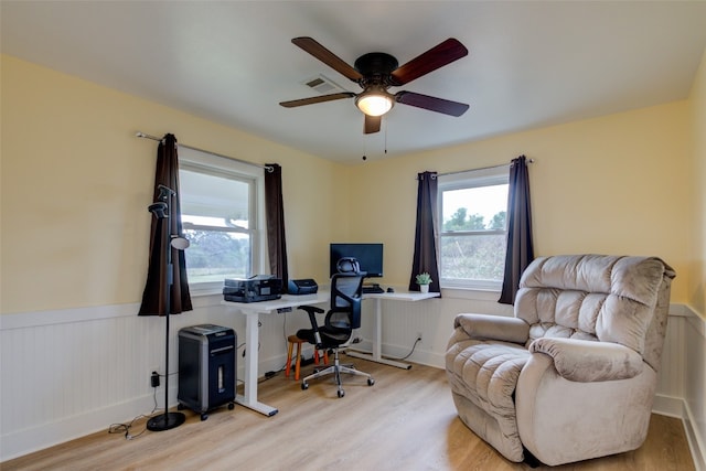 office with light wood-type flooring and ceiling fan