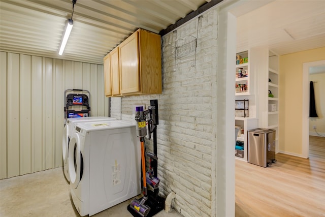 clothes washing area featuring cabinets, independent washer and dryer, and light hardwood / wood-style floors