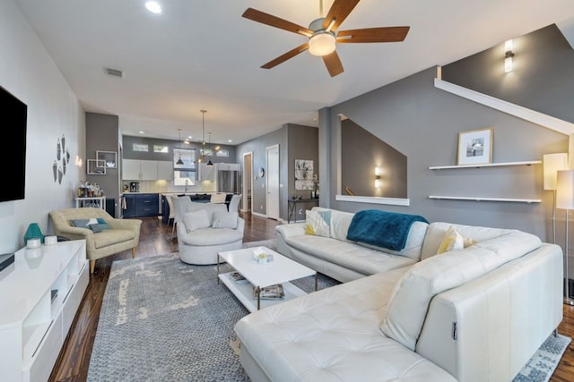 living room featuring sink, ceiling fan with notable chandelier, and dark hardwood / wood-style floors