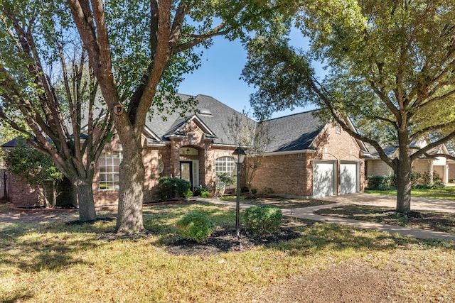 3600 Sawmill Dr, Austin, TX 78749 - view of front facade with concrete driveway, a garage, a front yard, brick siding, and a shingled roof