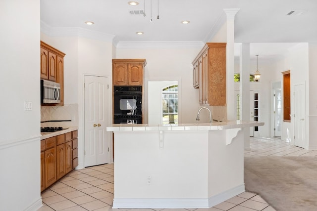 3600 Sawmill Dr, Austin, TX 78749 - kitchen with black appliances, a peninsula, decorative backsplash, recessed lighting, and a breakfast bar area