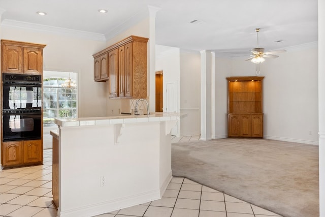 3600 Sawmill Dr, Austin, TX 78749 - kitchen featuring tile counters, light colored carpet, a ceiling fan, a peninsula, and a kitchen bar