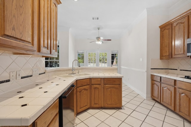3600 Sawmill Dr, Austin, TX 78749 - kitchen featuring stainless steel appliances, a peninsula, tile countertops, ceiling fan, and ornamental molding