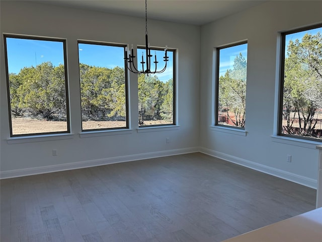 unfurnished dining area with dark hardwood / wood-style floors and a chandelier