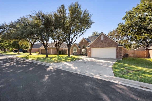 view of front of house with cooling unit, a garage, and a front yard