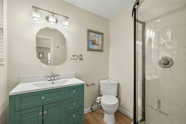 bathroom featuring toilet, a shower with door, vanity, and hardwood / wood-style flooring