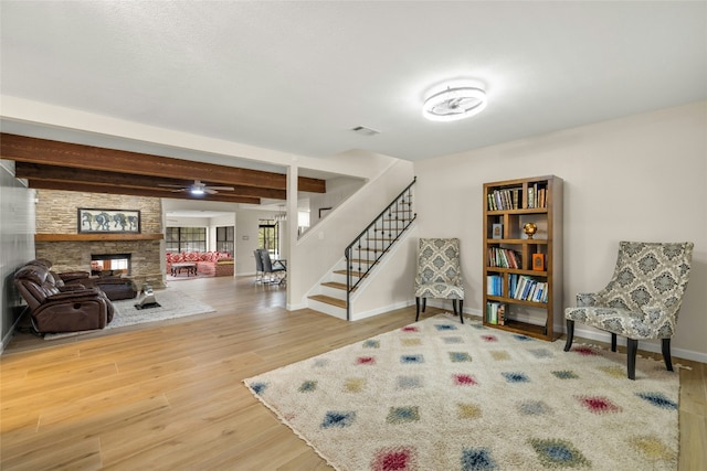 interior space with beamed ceiling, hardwood / wood-style floors, and a stone fireplace