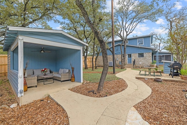 view of yard featuring outdoor lounge area, ceiling fan, and a patio