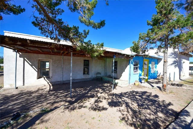 view of front facade with metal roof and stucco siding