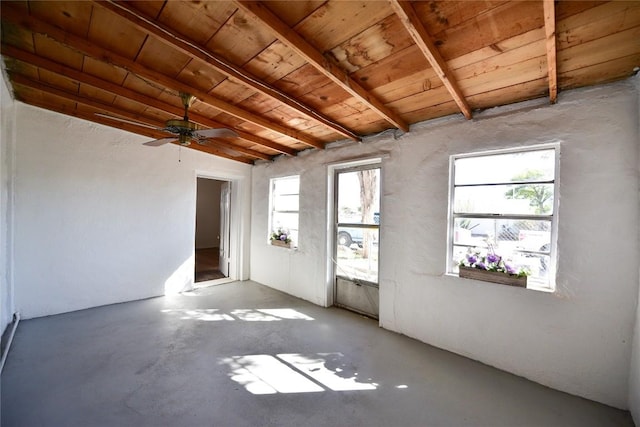 spare room with concrete flooring, ceiling fan, wooden ceiling, and beam ceiling