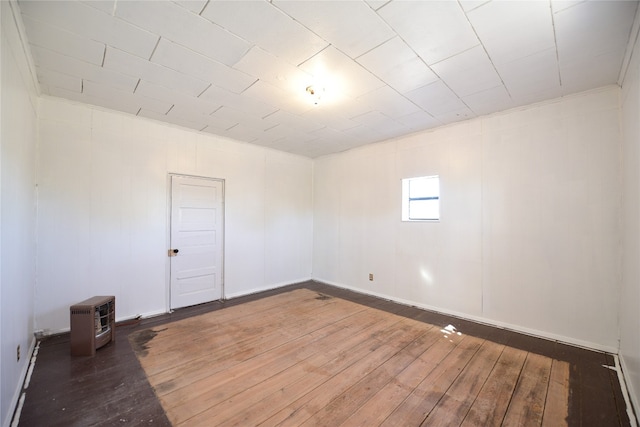 spare room with heating unit and hardwood / wood-style flooring