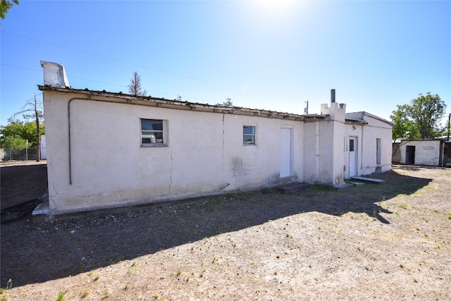 back of house featuring stucco siding