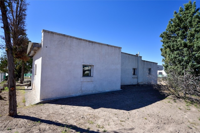 view of side of home with stucco siding