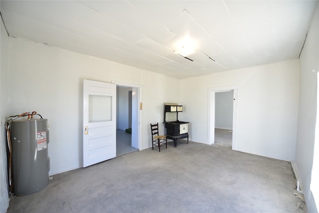 unfurnished room featuring water heater and unfinished concrete flooring