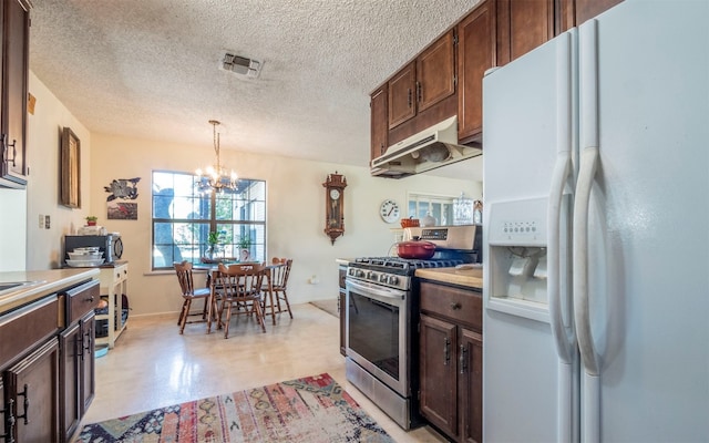 kitchen featuring an inviting chandelier, stainless steel range with gas cooktop, white fridge with ice dispenser, a textured ceiling, and decorative light fixtures