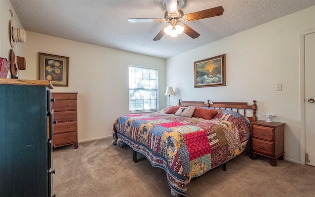 bedroom featuring ceiling fan, light colored carpet, and a textured ceiling