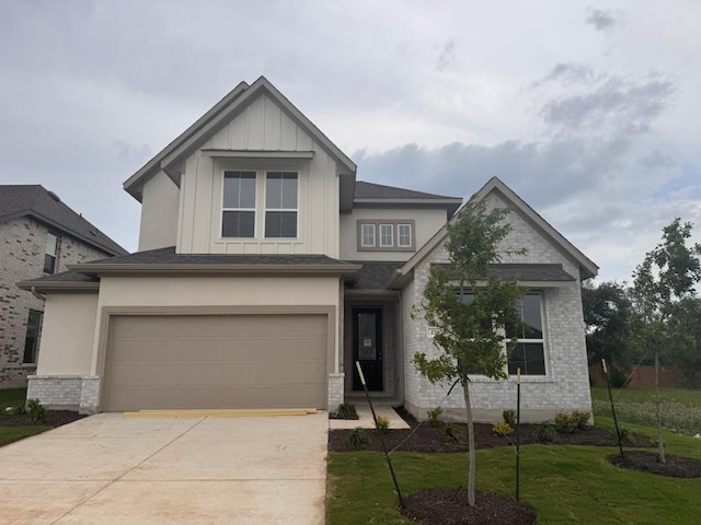 278 Smithsonian Ln, Kyle, TX 78640 - view of front of house featuring a garage, driveway, a front lawn, and board and batten siding