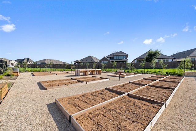 view of playground featuring a residential view, a vegetable garden, and fence