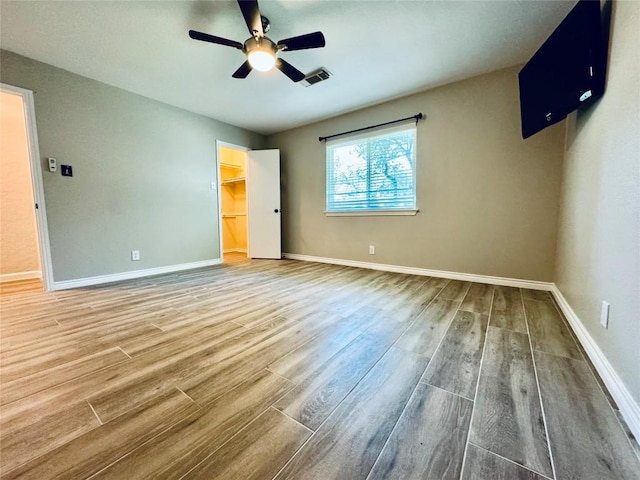 unfurnished bedroom with wood finished floors, visible vents, and baseboards