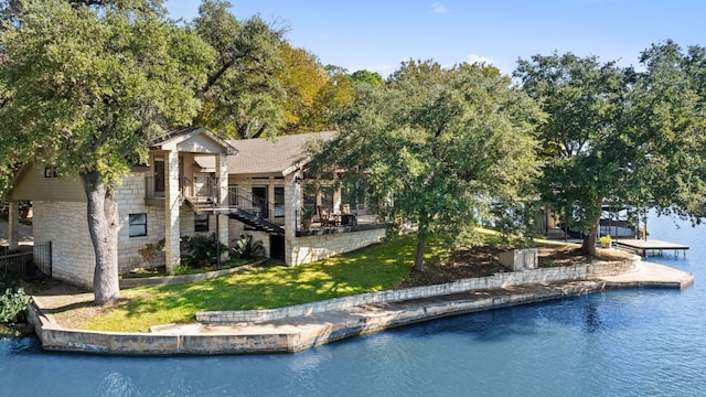 back of property featuring a yard and a water view