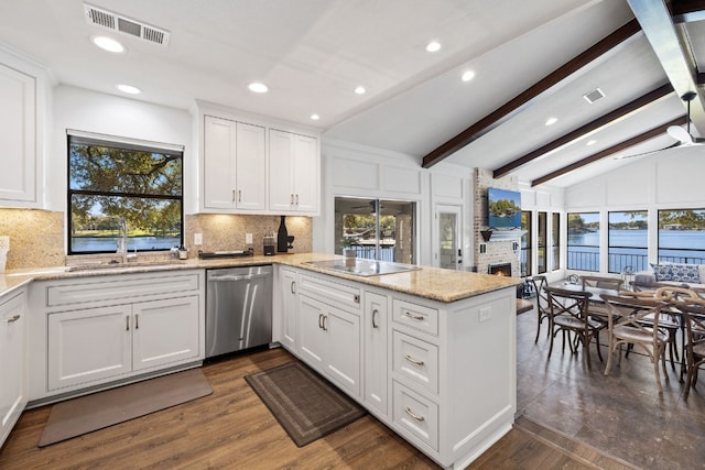 kitchen featuring kitchen peninsula, stainless steel dishwasher, vaulted ceiling with beams, black electric cooktop, and white cabinetry