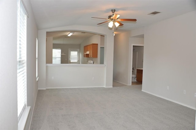 12817 Paloma Blanca Way, Del Valle, TX 78617 - unfurnished living room with ceiling fan, light colored carpet, arched walkways, and lofted ceiling