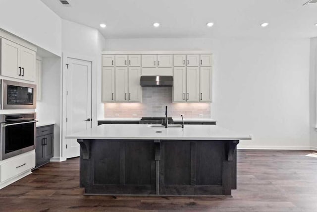 2109 Tobiano Trce, Georgetown, TX 78633 - kitchen featuring stainless steel oven, under cabinet range hood, built in microwave, light countertops, and recessed lighting