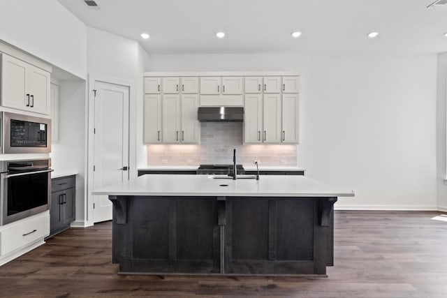 2109 Tobiano Trce, Georgetown, TX 78633 - kitchen with oven, under cabinet range hood, built in microwave, light countertops, and recessed lighting
