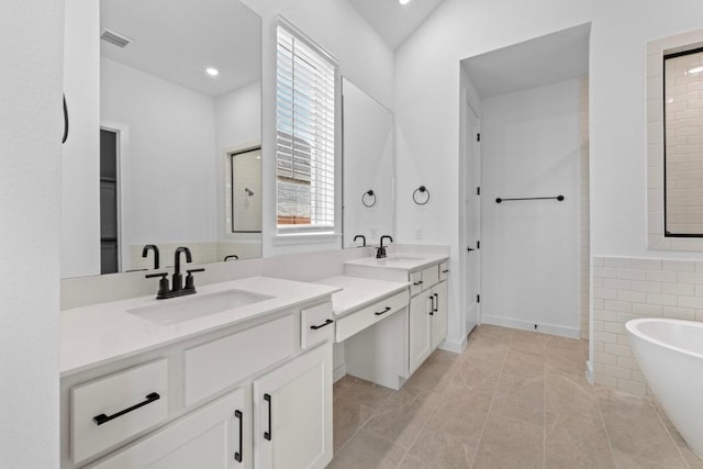 2109 Tobiano Trce, Georgetown, TX 78633 - bathroom with a soaking tub, vanity, tile patterned flooring, and recessed lighting