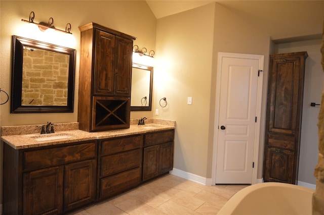 bathroom with tile patterned flooring, vanity, a tub, and vaulted ceiling