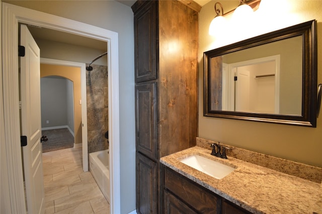 bathroom with tile patterned flooring, vanity, and tiled shower / bath