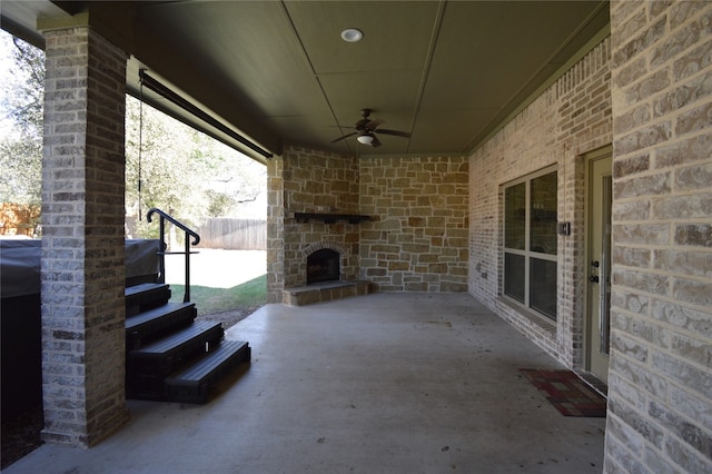 view of patio / terrace featuring an outdoor stone fireplace and ceiling fan