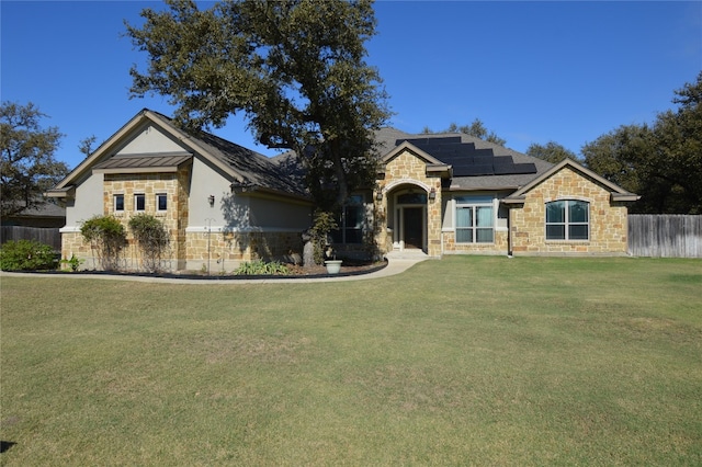 view of front of house with a front yard and solar panels