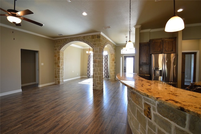 kitchen with pendant lighting, dark wood-type flooring, crown molding, light stone counters, and stainless steel fridge with ice dispenser