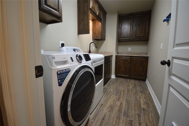 clothes washing area featuring cabinets, dark hardwood / wood-style flooring, independent washer and dryer, and sink