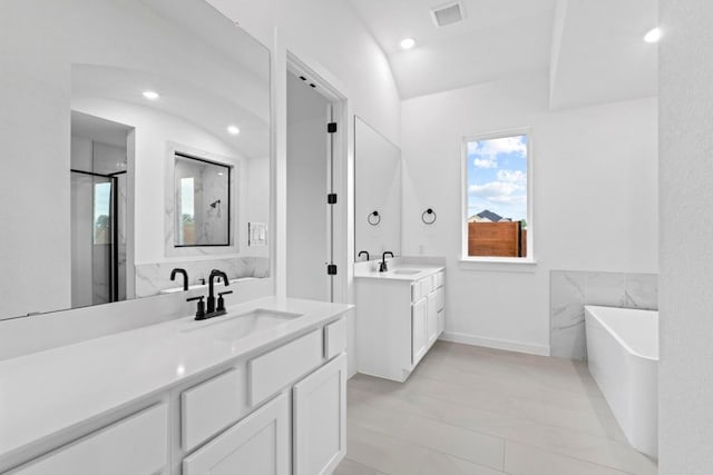 2113 Tobiano Trce, Georgetown, TX 78633 - full bath with a freestanding bath, two vanities, a stall shower, and recessed lighting