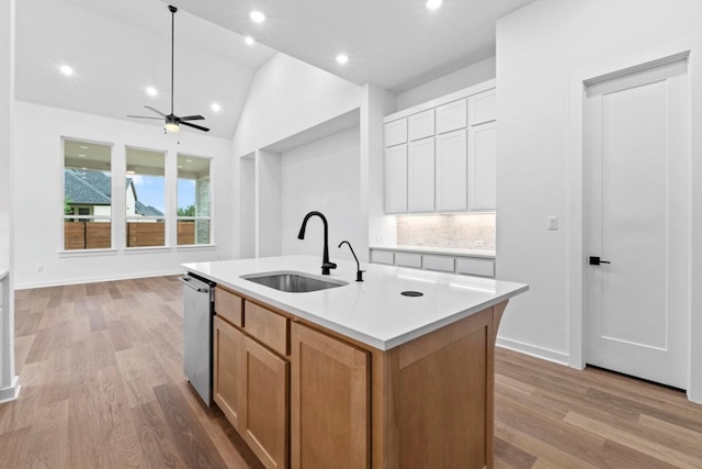 2113 Tobiano Trce, Georgetown, TX 78633 - kitchen with dishwasher, a ceiling fan, light wood-style floors, light countertops, and lofted ceiling