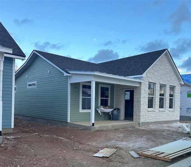 rear view of property featuring covered porch