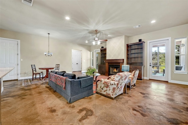 living area featuring recessed lighting, visible vents, a warm lit fireplace, and baseboards