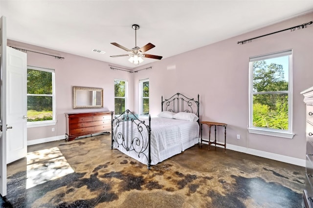 bedroom with finished concrete floors, visible vents, a ceiling fan, and baseboards