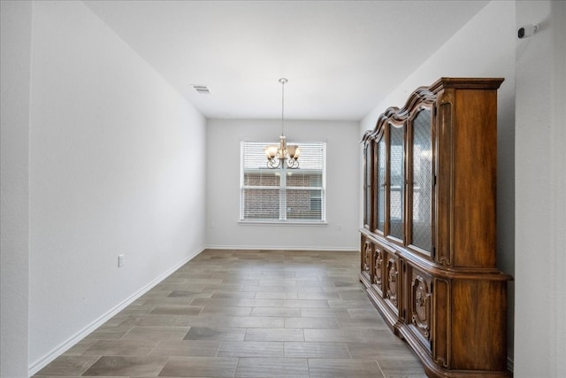 unfurnished dining area with hardwood / wood-style flooring and an inviting chandelier