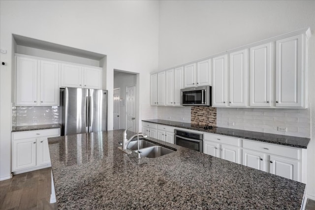 kitchen featuring white cabinetry, dark hardwood / wood-style flooring, an island with sink, and stainless steel appliances