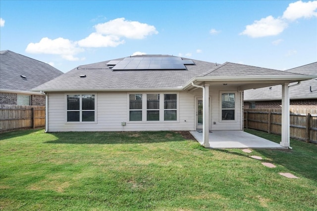 rear view of property featuring solar panels, a yard, and a patio