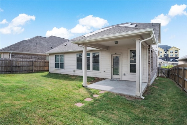 back of property with a patio area and a yard