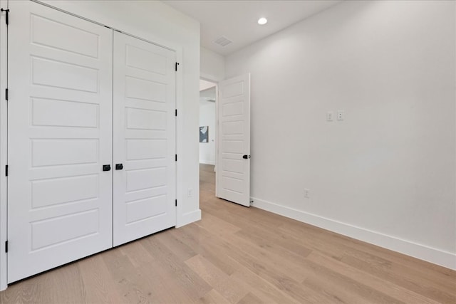 unfurnished bedroom featuring a closet and light hardwood / wood-style flooring