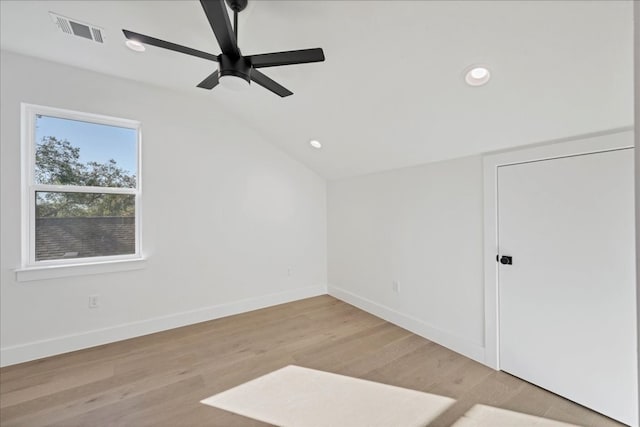 empty room featuring ceiling fan, lofted ceiling, and light hardwood / wood-style flooring